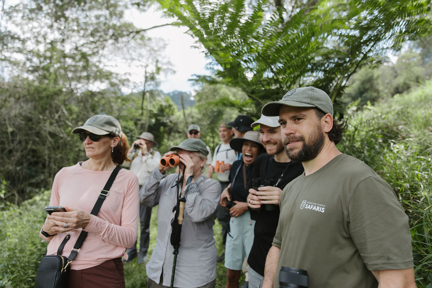 Group watching wildlife with binoculars in coastal forest