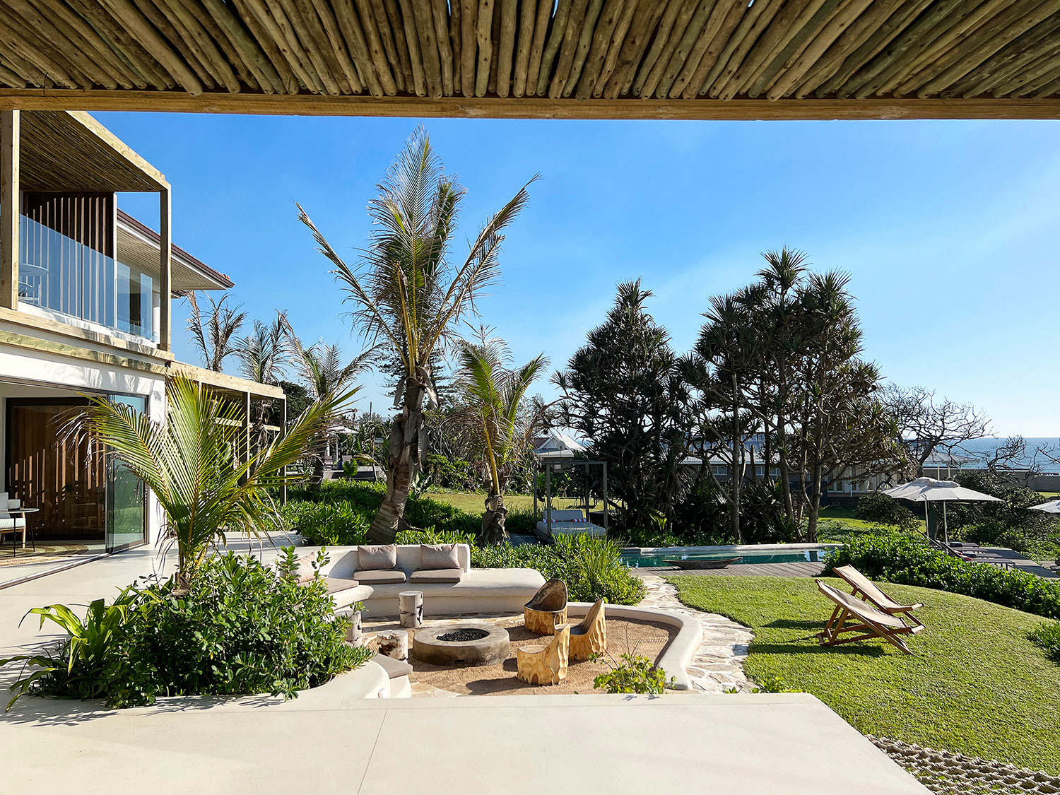 Sala Beach House exterior framed by palms on the coast