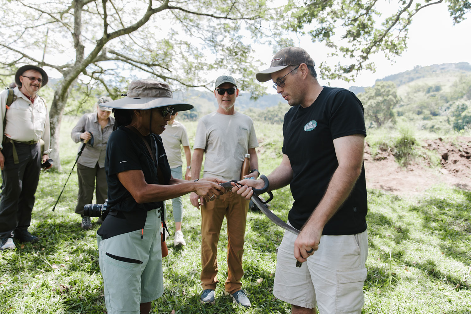 A guide sharing a find with guests on a forest walk